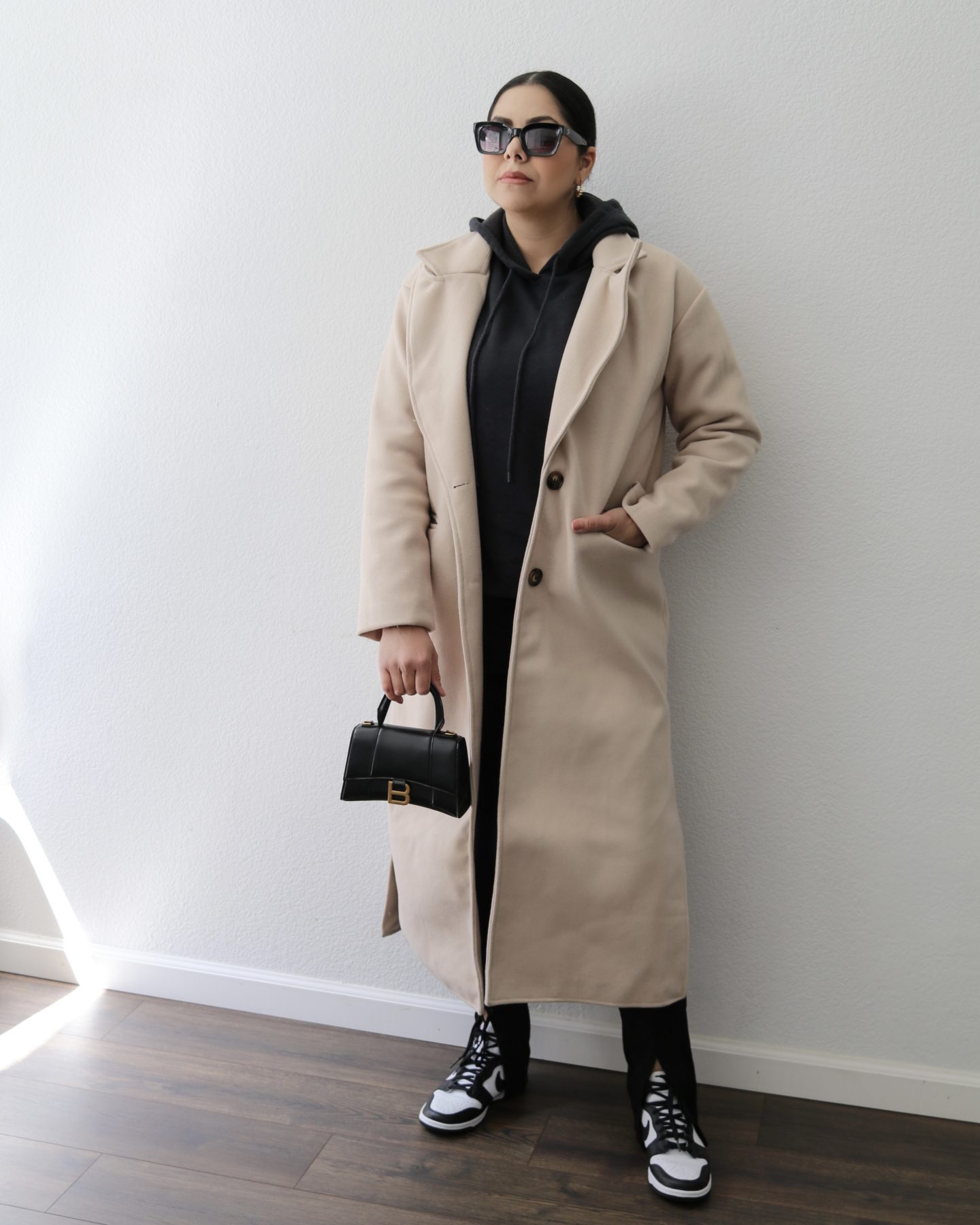 long cream coat outfit with black and white dunks, how to style panda dunks, chic sneakers outfit