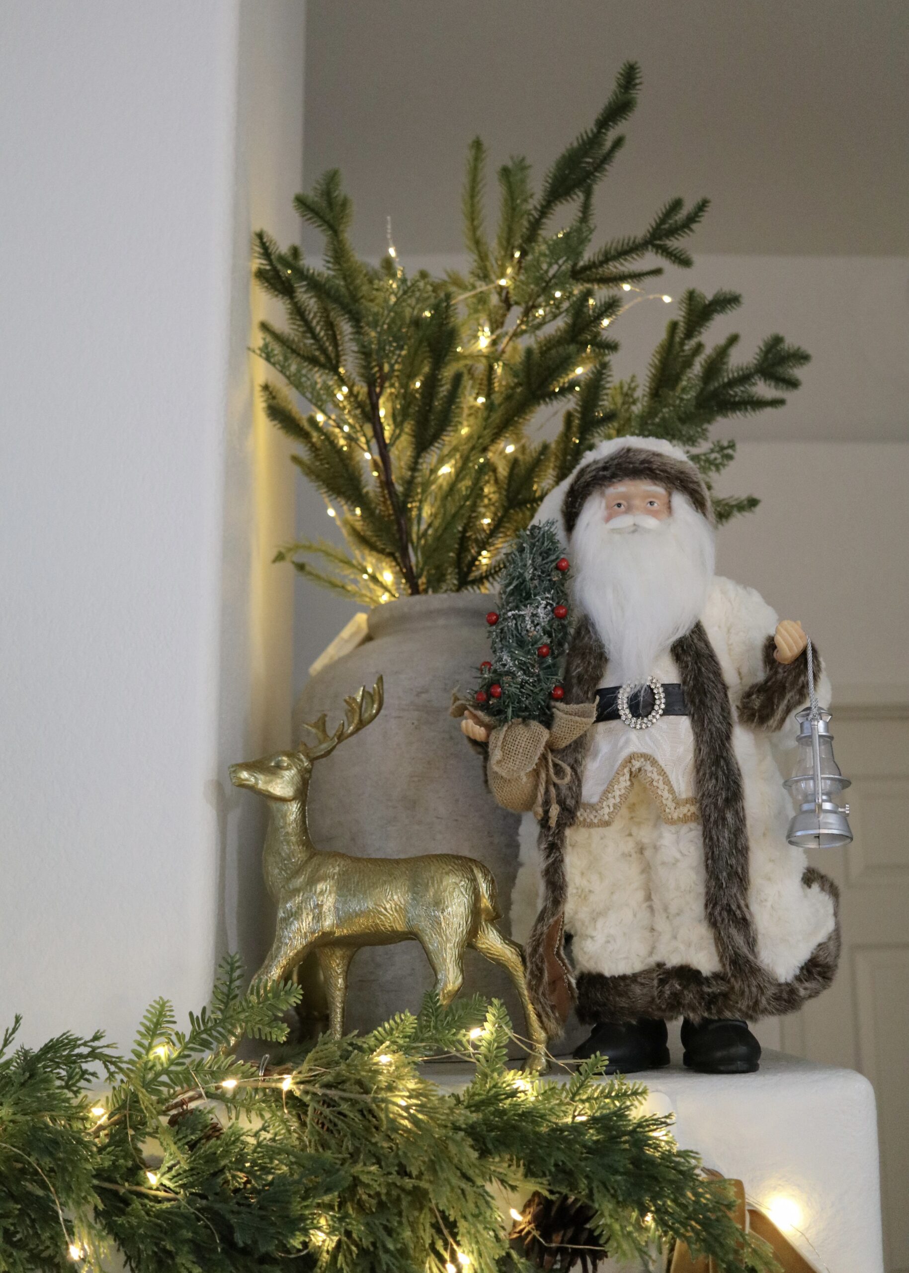 estive decor santa figurine, gold reindeer decorative figurine, pine branches in vase for holiday decor