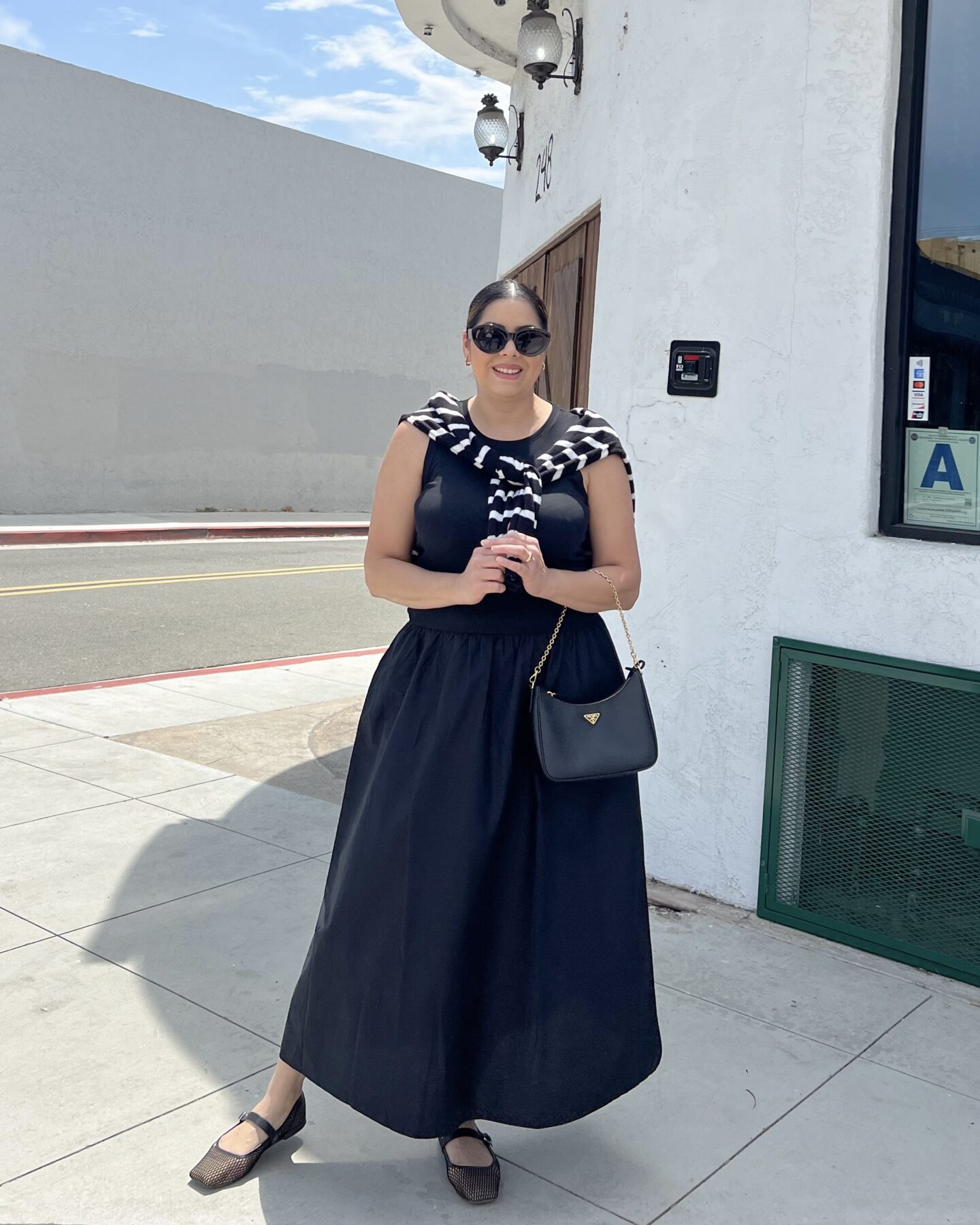 Reviving my style blog in 2025, style blogger in San Diego wearing a black maxi dress and striped sweater over the shoulders